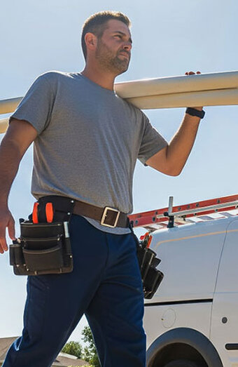 Plumber Carrying Pipes Van